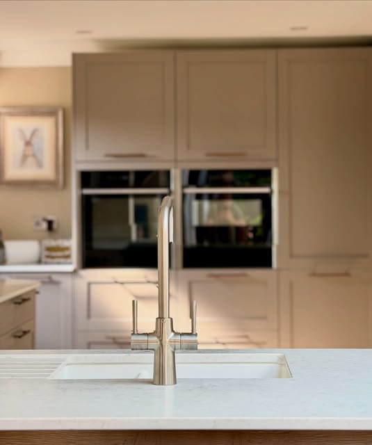 Neutral Shaker cabinetry, integrated ovens and a pale worktop.