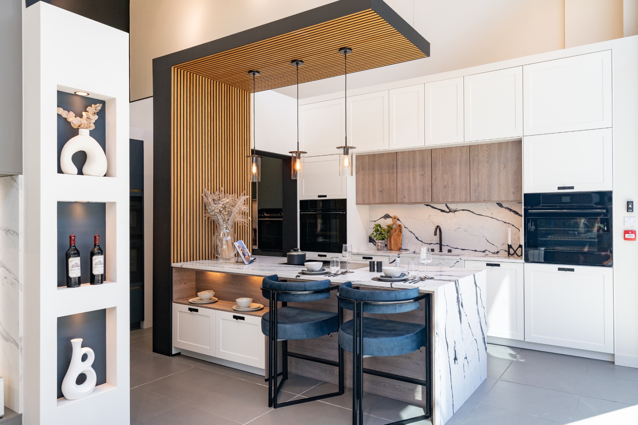 Whiteley showroom kitchen with white Shaker cabinetry, timber detailing and a stone-effect island
